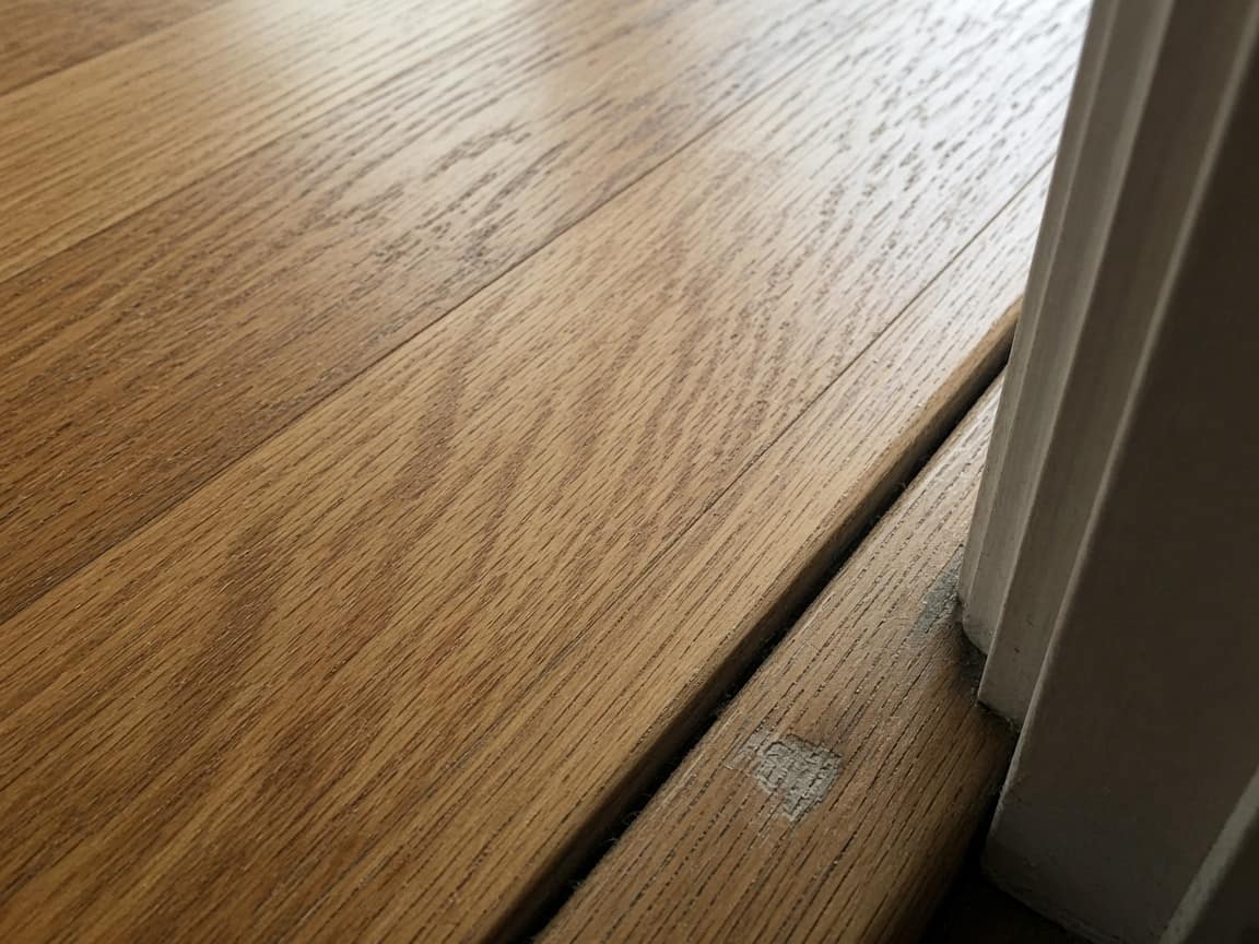 Gap and scuff at the doorway threshold